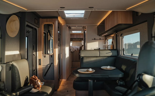 Homme coupant des oignons dans la cuisine d’un camping-car – Poêle posée sur la cuisinière à gaz