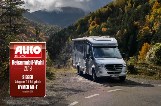 HYMER ML-T next to lanes in an autumnal mountain landscape and emblem awarding motorhome choice semi-integrated 2019