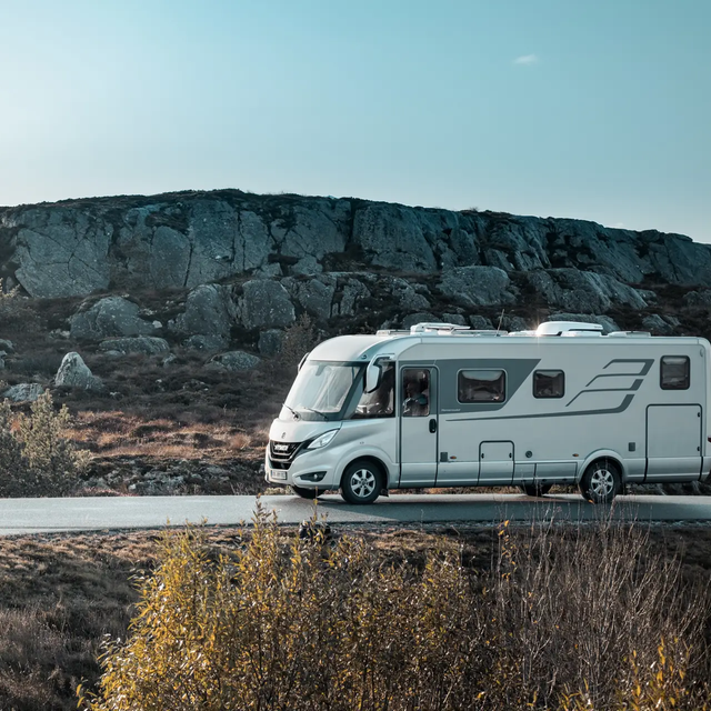 HYMER B-Class MasterLine from the side on a road in Scandinavia with a typical hilly landscape