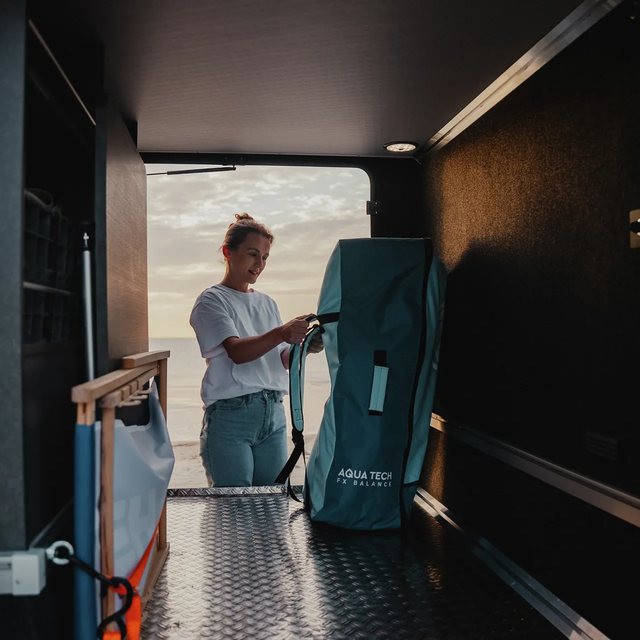 Man unloading a mountain bike from the rear garage of a HYMER motorhome