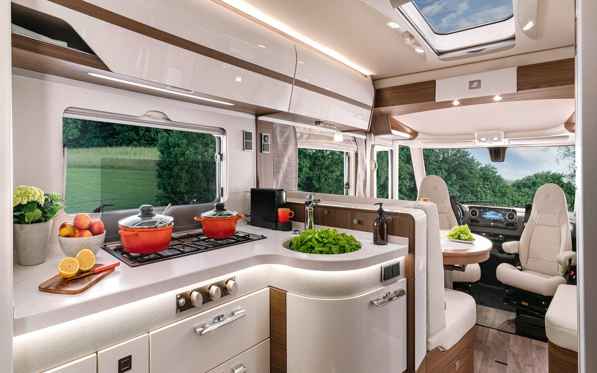 Bright kitchen work surface with 3-burner stove and cooking utensils in the HYMER-B MasterLine