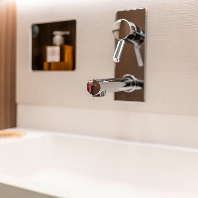 Designer washbasin with integrated faucet, storage and wall-mounted fittings in the bathroom of the HYMER B-Class MasterLine
