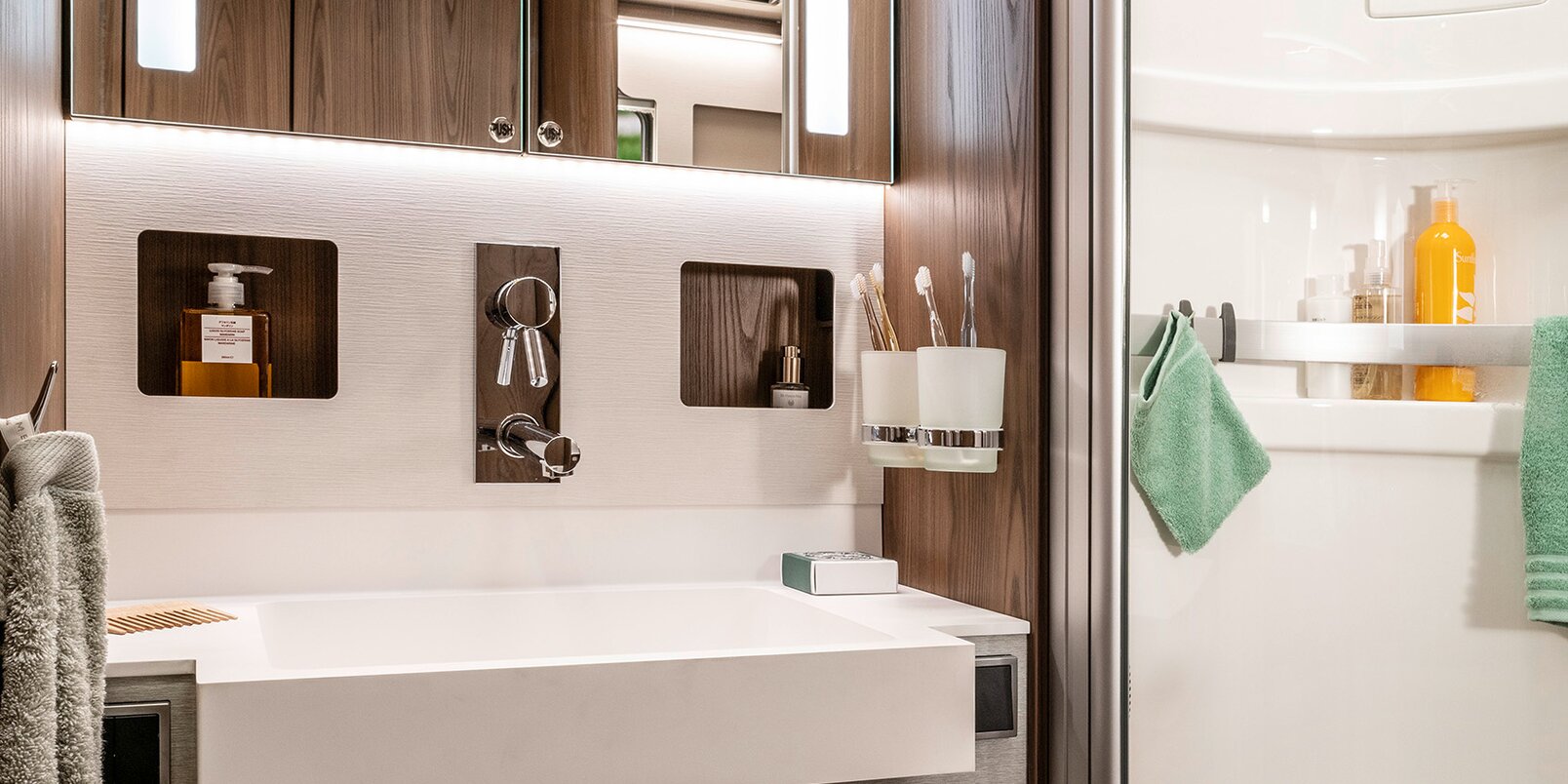Bagno di tipo salone nell’HYMER classe B MasterLine con armadio illuminato con specchio e cassetti estraibili sotto il lavandino