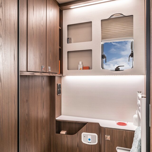 Bathroom with storage space, wash basin; Towel holder, mirror, coat hook and toilet in the HYMER B-ML I 880