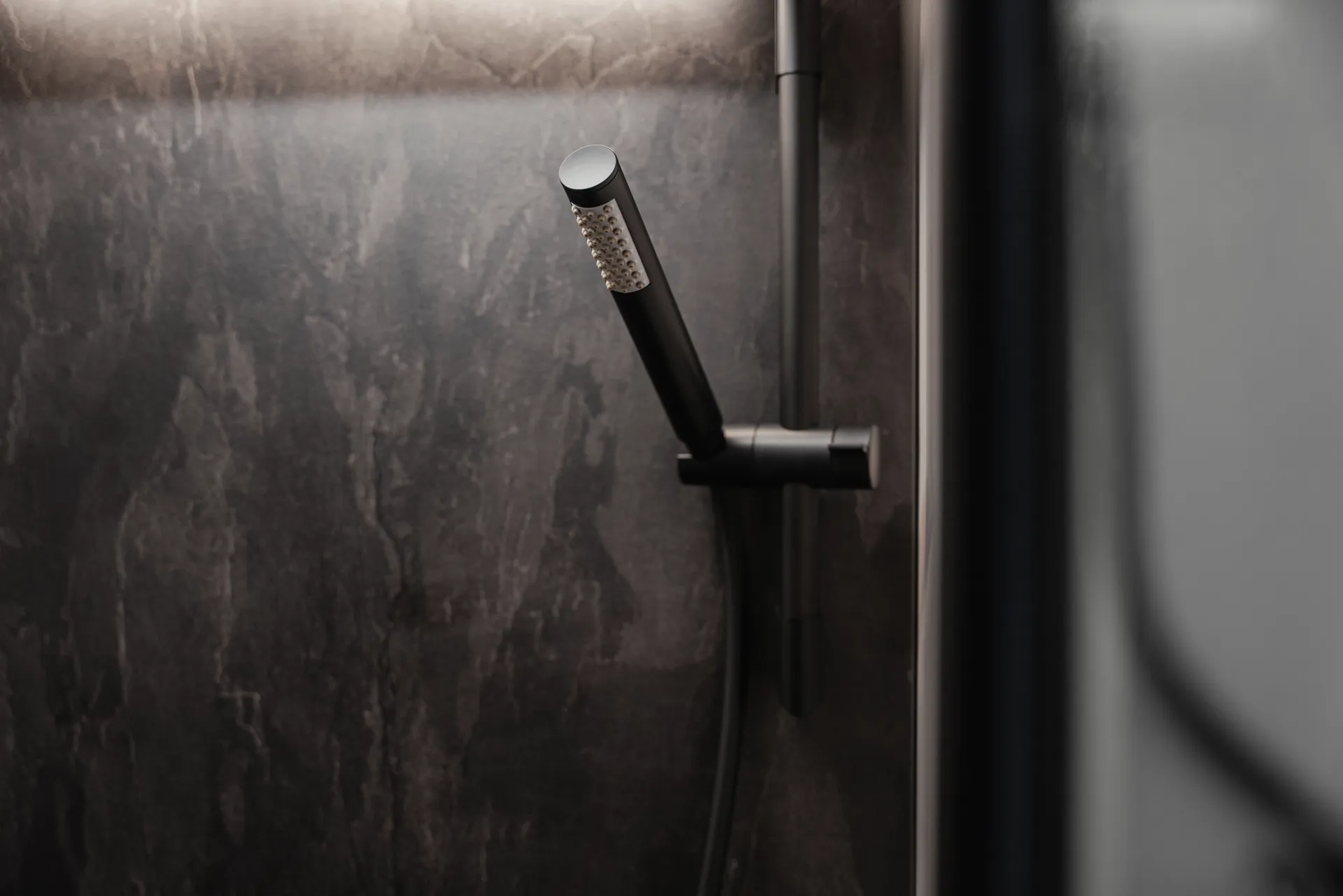 Les robinetteries noir mat et les surfaces haut de gamme confèrent à l’espace douche son caractère moderne et architectural.