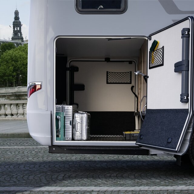 The door of the rear garage of the HYMER B MasterLine, which is loaded with two silver suitcases