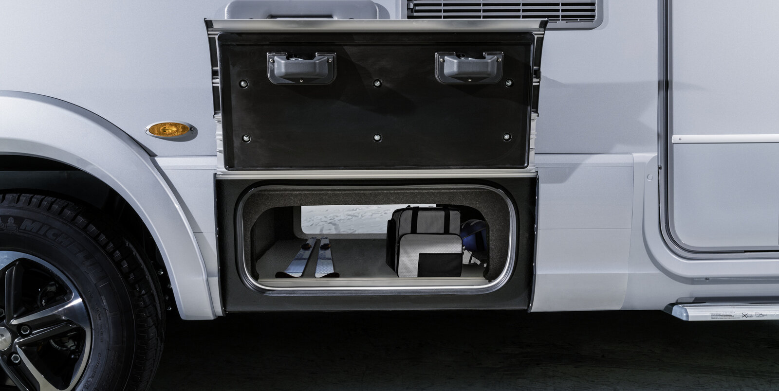Through-loading compartment open on both sides, loaded with a pair of skis and bags in the HYMER B-MasterLine with SLC chassis
