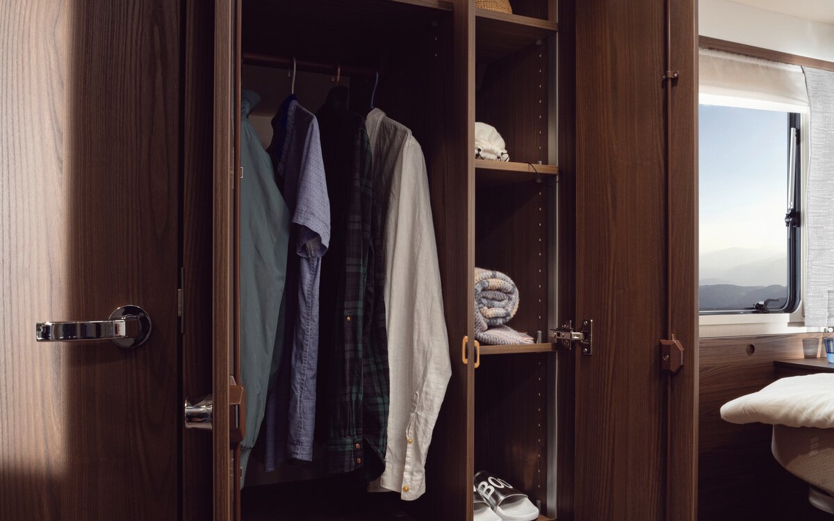 Illuminated two-door wardrobe with two drawers, several shelves and clothes rail in the HYMER B-MasterLine