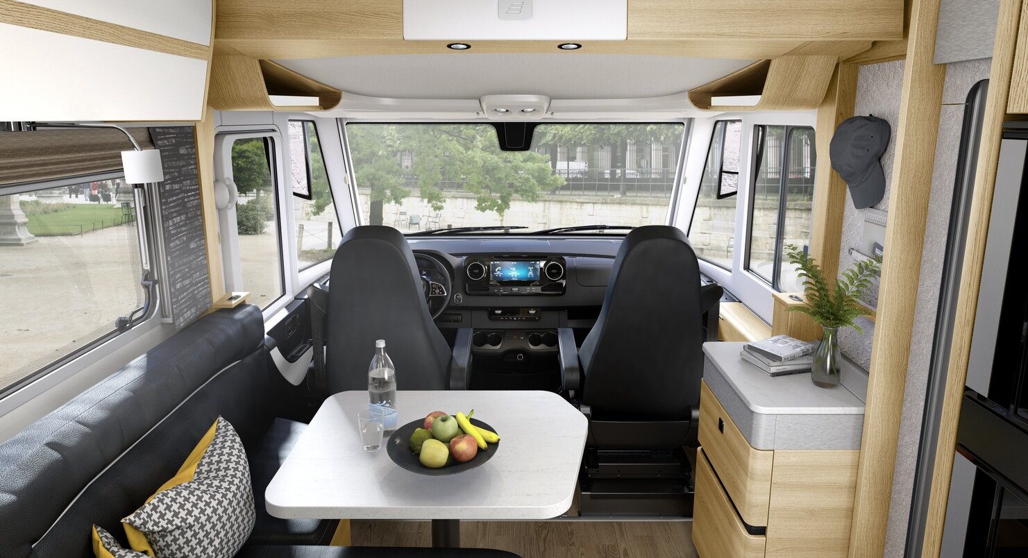 Spazio abitativo allestito nell’autocaravan HYMER classe B MasterLine, con dinette nera e mobilio chiaro