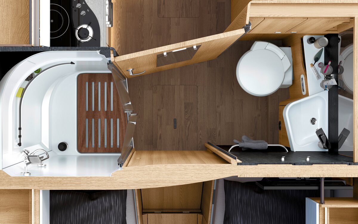 Bathroom in the HYMER B-ML T motorhome with white toilet, wash basin and separate shower with wooden slatted frame