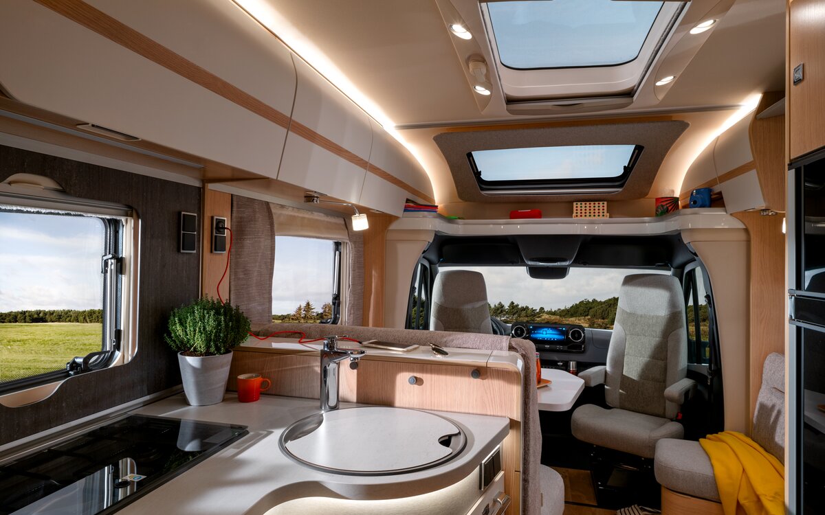 Storage board filled with toys and overhead storage cupboards above the driver's seats and skylight in the HYMER MasterLine T