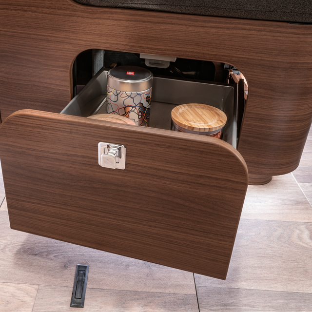 Storage drawer opened and filled with storage boxes under the seating area in the HYMER MasterLine