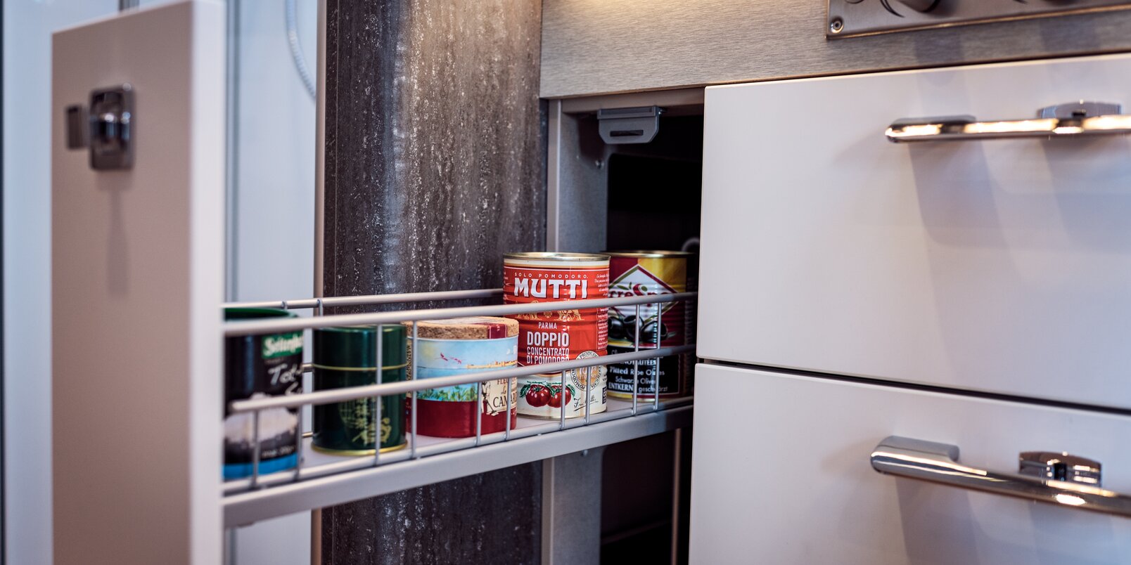geöffneter und mit Vorrat befüllter Apothekerschrank im Küchenblock bei der HYMER B-Klasse MasterLine
