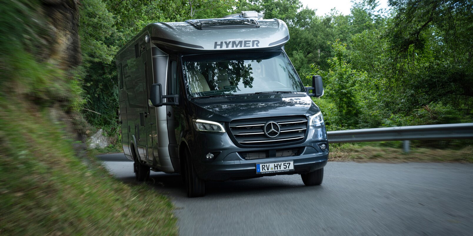 HYMER MasterLine T on a Mercedes chassis driving uphill through a forested road