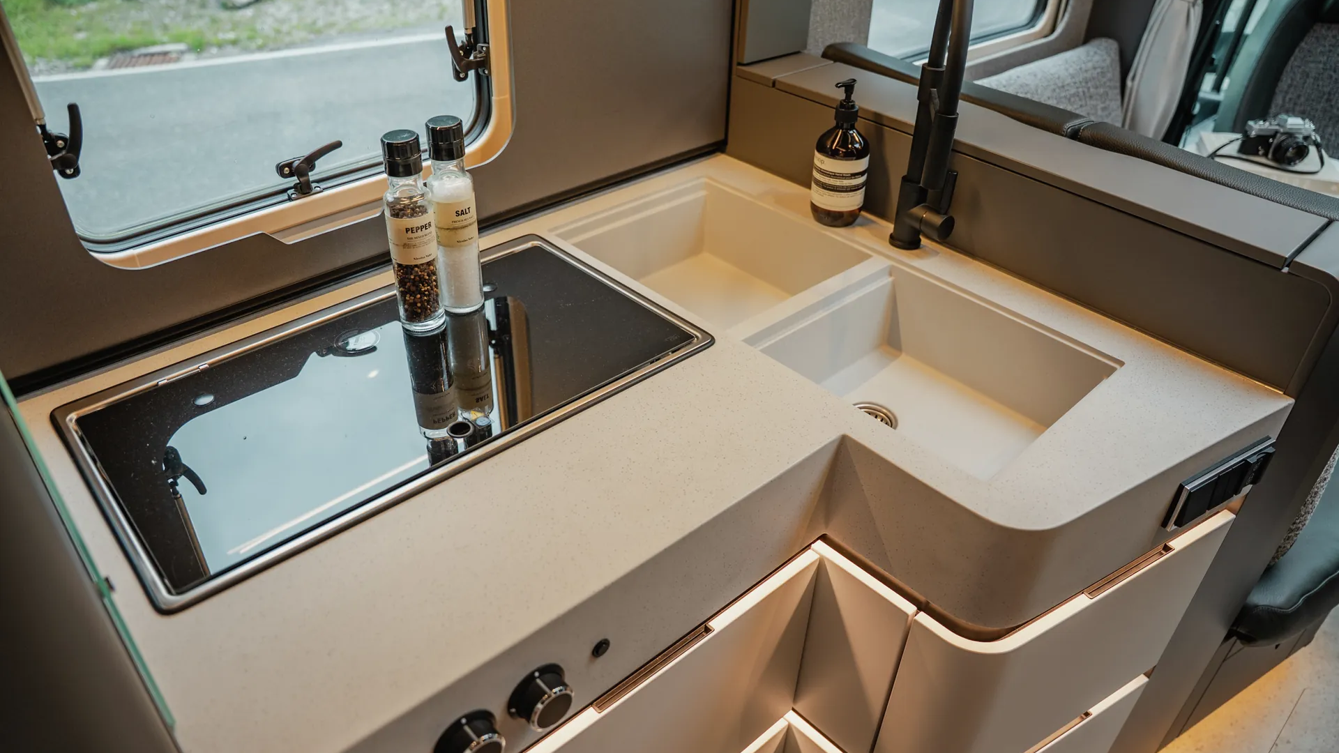 The optional solid-surface worktop combines a premium appearance with generous functionality. Two large sinks and an elegant swan-neck tap provide comfort for everyday life on the road.