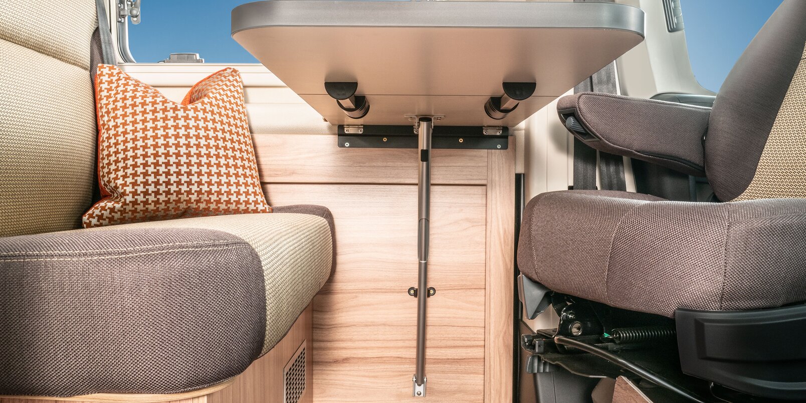 Opened storage compartment filled with utensils under the table in the living area and bench in the HYMER Fiat Camper Van