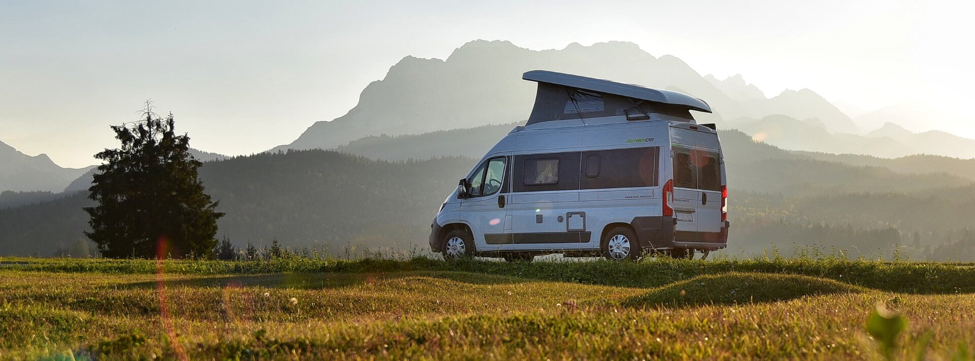 Fiat HYMER Camper Van in meadow with wooded hills