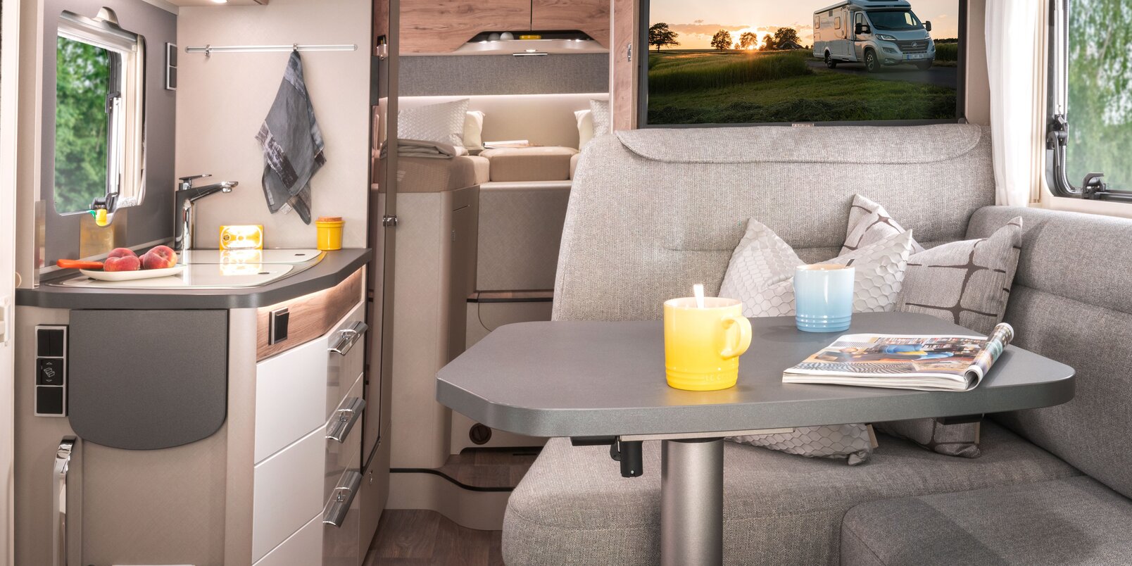 Lounge seating group with driver's cab, set table, TV plasma and kitchen block in the HYMER Exsis-i 580