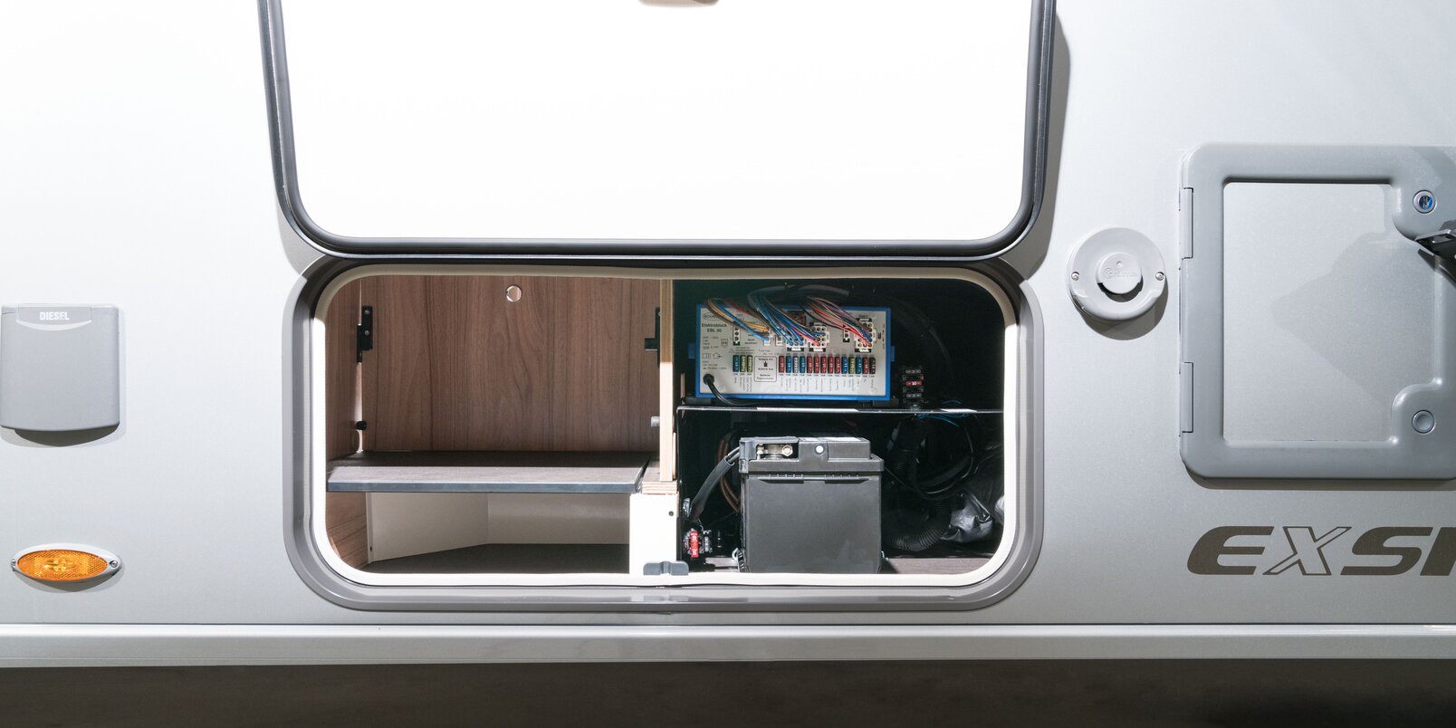 Storage compartment with open external flap under the seating area for living area battery and electric block in the HYMER Exsis