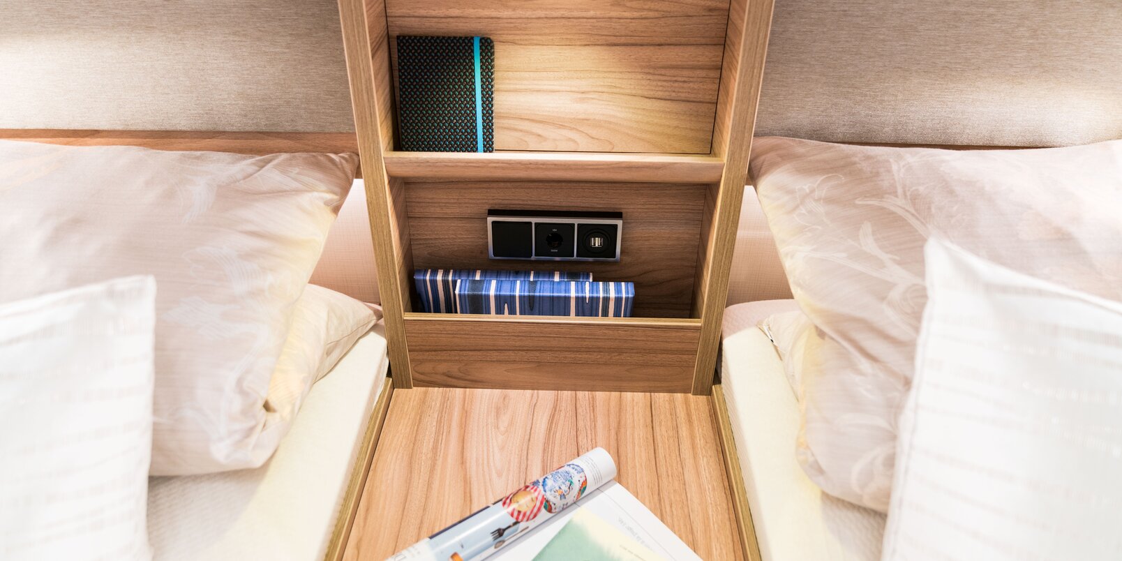 Open, filled storage shelf in the sleeping area between the twin beds in the rear of the HYMER Exsis-i