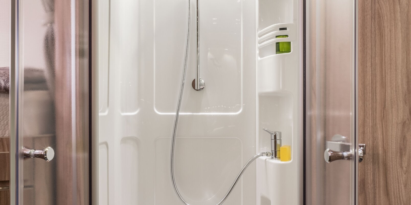 Shower cubicle with wooden slatted frame, skylight, shelf for shower gel, shower head, shelf rail in the HYMER Exsis-i 678