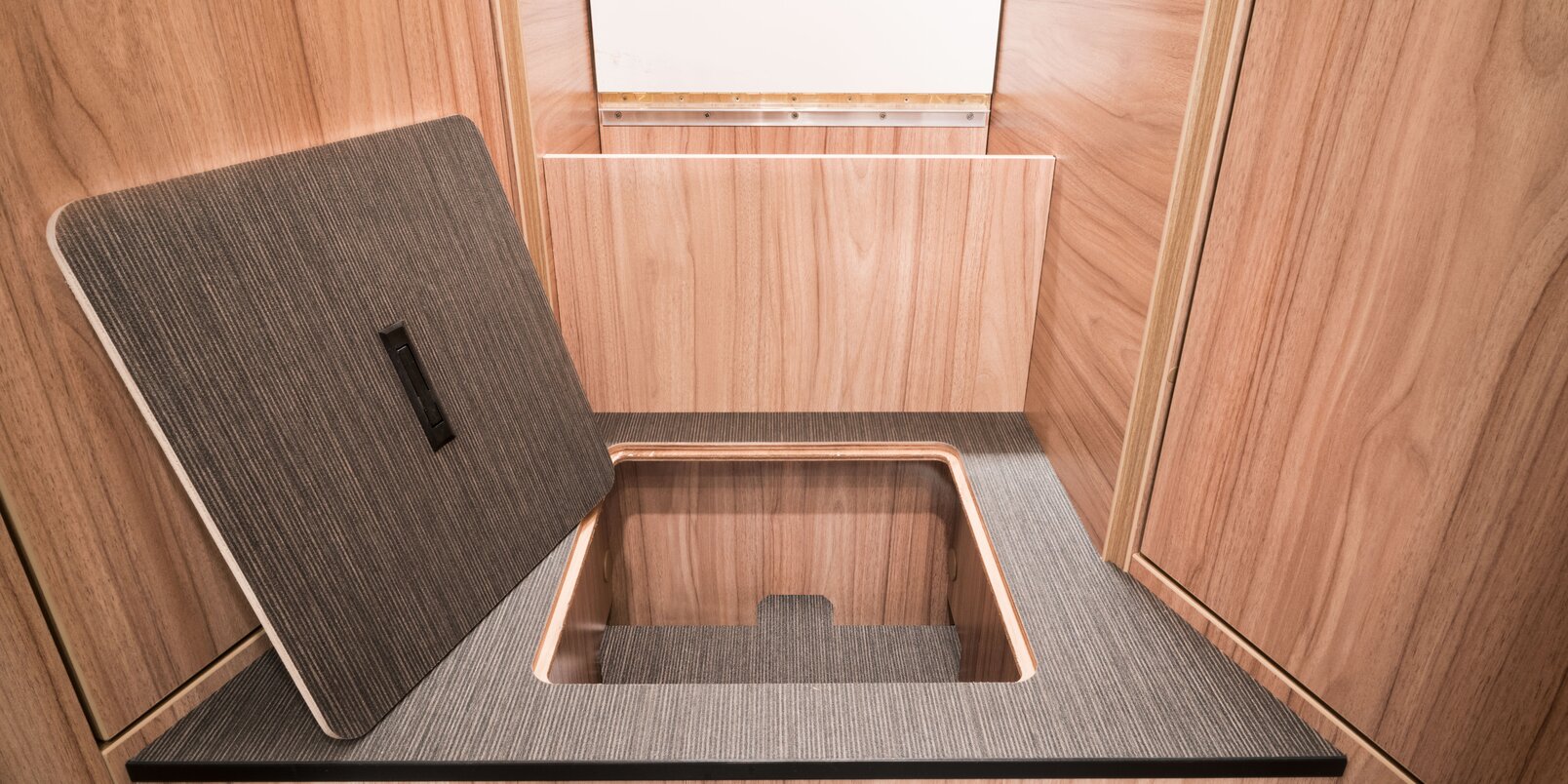 Open storage compartment in the stairs to the sleeping area in the rear of the HYMER Exsis