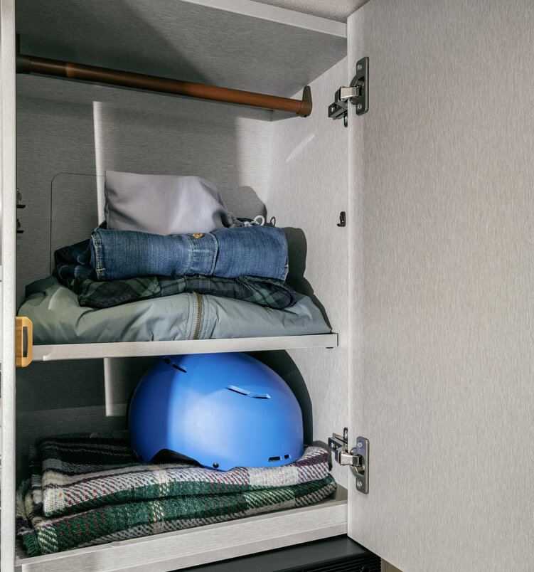 HYMER Camper Van Free S 600 avattu vaatekaappi vaatetangolla, vaatteilla täytettyjä hyllyjä, säilytystilaa 