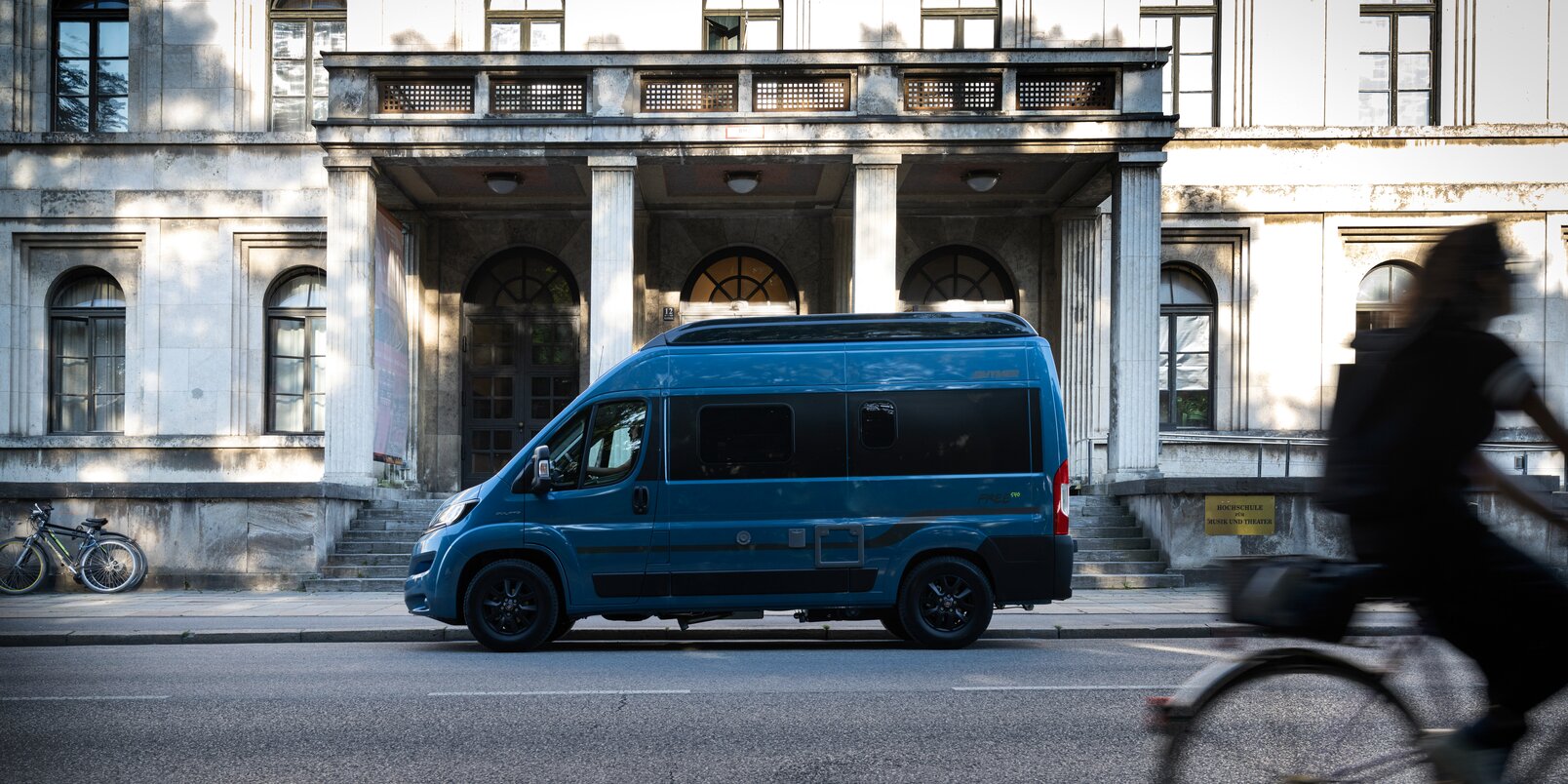 Il Camper Van Free HYMER colore blu-metallic è parcheggiato davanti ad un edificio vecchio in città