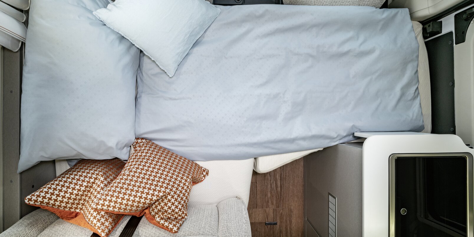 Dinette trasformata in letto, con lenzuola e cuscino decorativo nel Free 602 HYMER