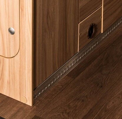 Built-in wood designs in the furniture and in the floor of the HYMER Grand Canyon S