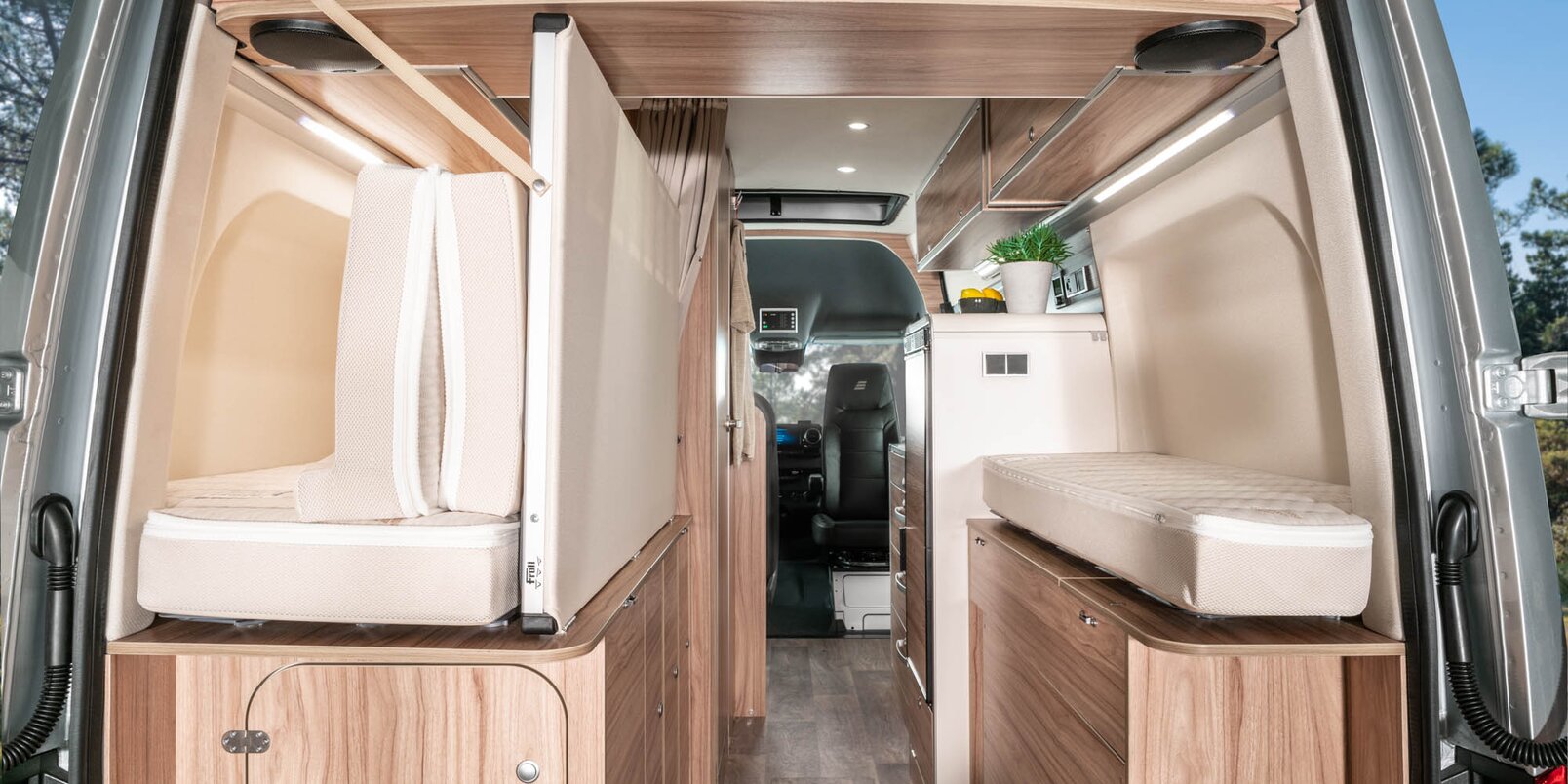 View from the rear to the driver's cab with the doors open, the bed frame folded up in the HYMER Grand Canyon S