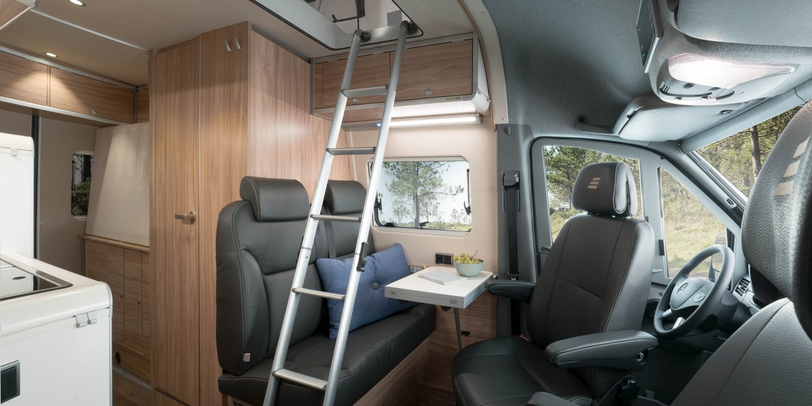 Ladder to the pop-top roof on the bench, table, driver's seats, living area to the rear in the HYMER Grand Canyon S