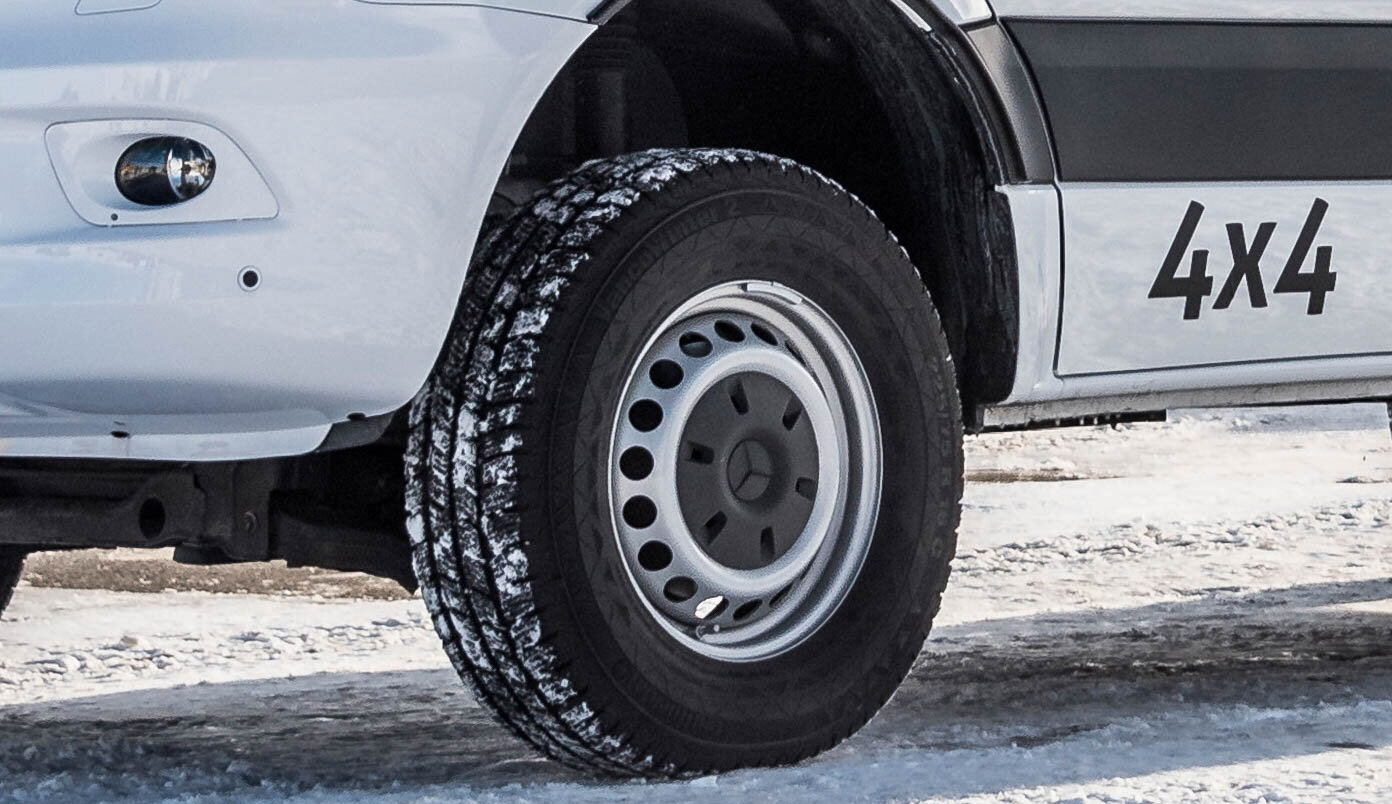 Voorzijde bestuurderszijde met 'all wheel' banden en 4x4-stickers op de HYMER Grand Canyon S