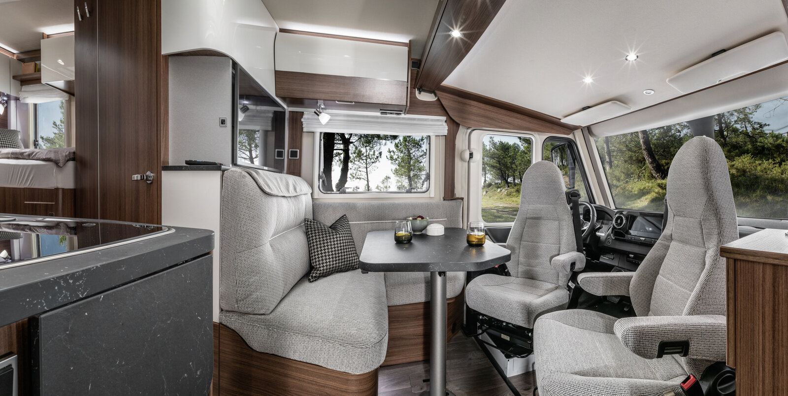 Lounge seating group with driver's seats and decorative cushions, set table in the HYMER B-MC I 580
