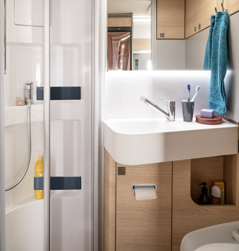 Bagno confortevole con cabina doccia, lavandino, specchio, toilette e utensili da bagno nell’HYMER ModernComfort