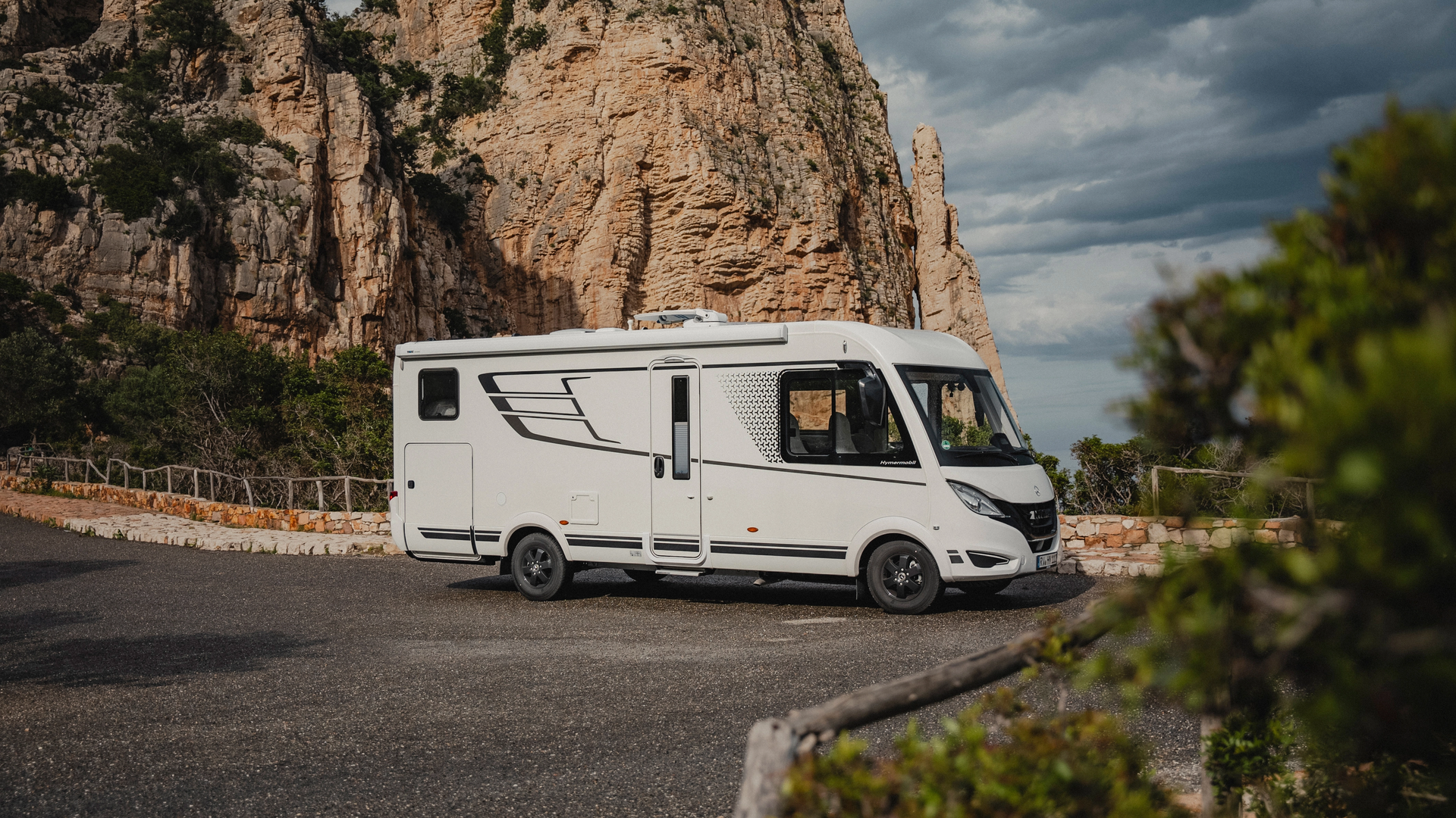 De HYMER B-MC-I maakt indruk met zijn sportieve ontwerp, gekenmerkt door dynamische lijnen en stijlvolle graphics. Ervaar de perfecte combinatie van elegantie en kracht die van reizen een stijlvol avontuur maakt.
