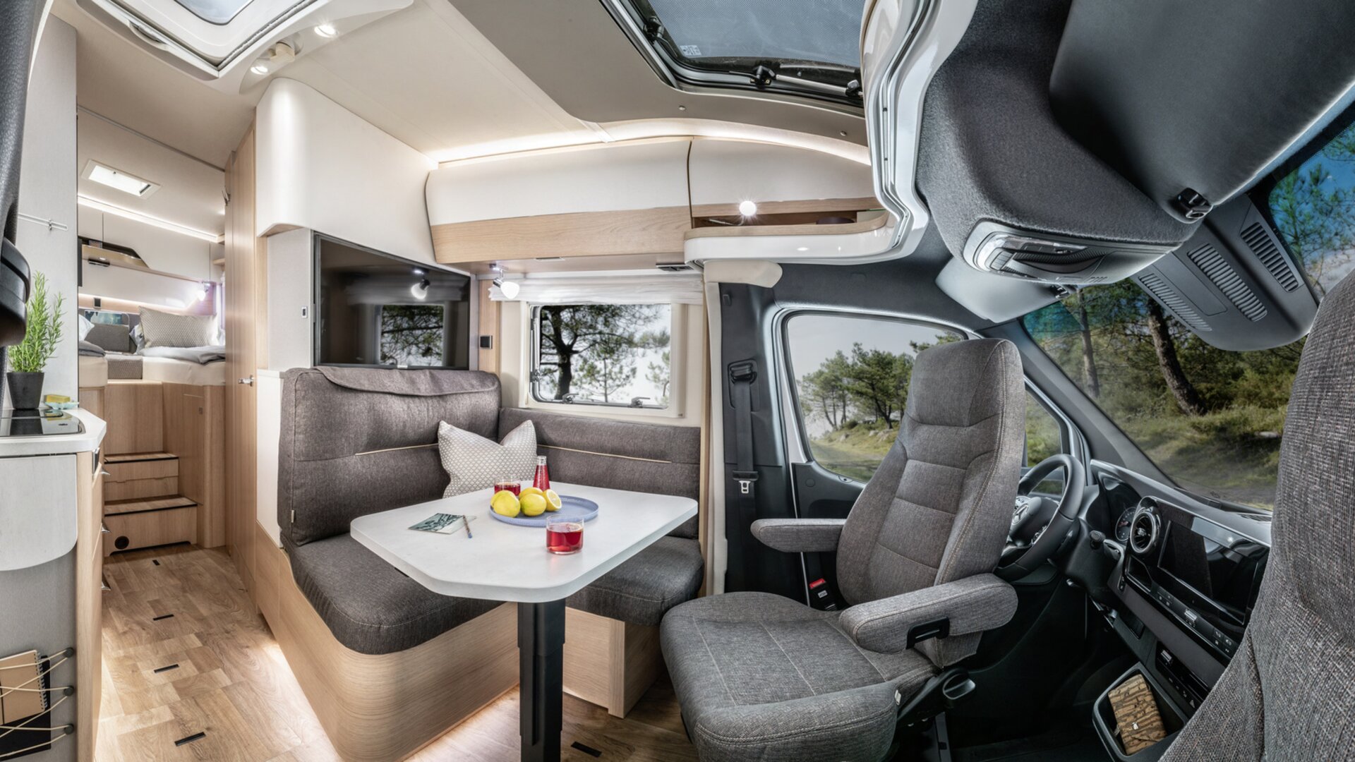 Wohnsitzgruppe mit Fahrerhaus, gedecktem Tisch, TV-Plasma und Küchenblock im HYMER B ModernComfort T