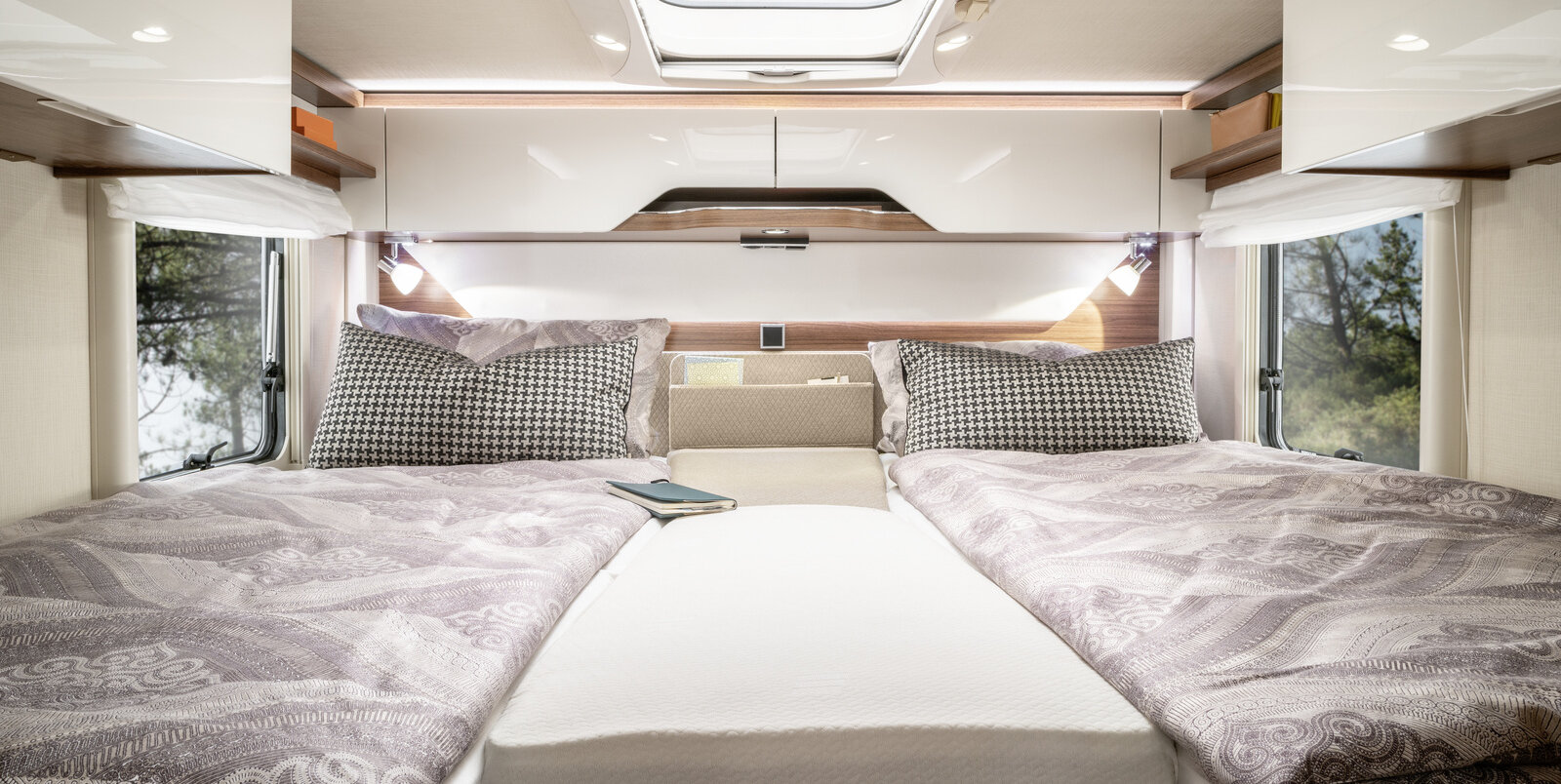 Lengthways single beds covered with bed linen and additional central cushion in the rear of the HYMER B ModernComfort T 580