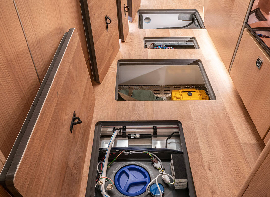 Living space storage compartments in the double floor of the HYMER B-MC SLC chassis for accommodating water tanks and other installations