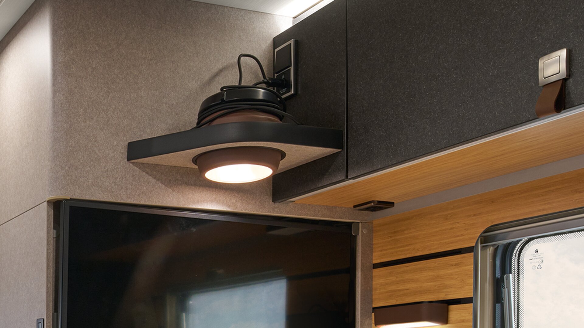 Die Multifunktionsleuchte im HYMER ML-T in der Stilwelt Native Bamboo wird als Pendelleuchte eingesetzt.
