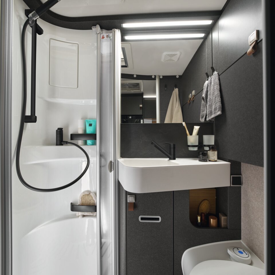 Über der Dusche des Bads im HYMER ML-T in der Stilwelt Native Bamboo befindet sich eine praktische Kleiderstange. Darüber ist ein Dachfenster.
