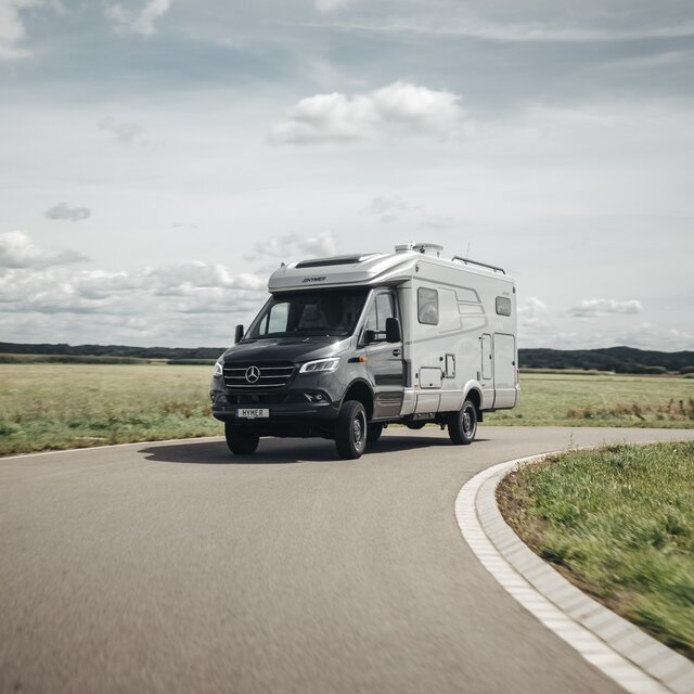Der HYMER ML-T ist frontal zu sehen und fährt um eine Kurve.