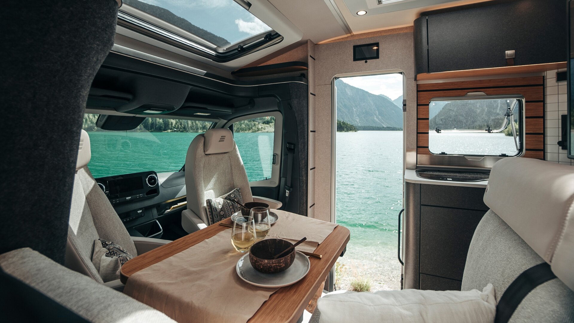 Beim Blick durch den Innenraum des HYMER ML-T in der Stilwelt Native Bamboo ermöglichen zahlreiche Fenster und Türen den Blick auf die Landschaft.