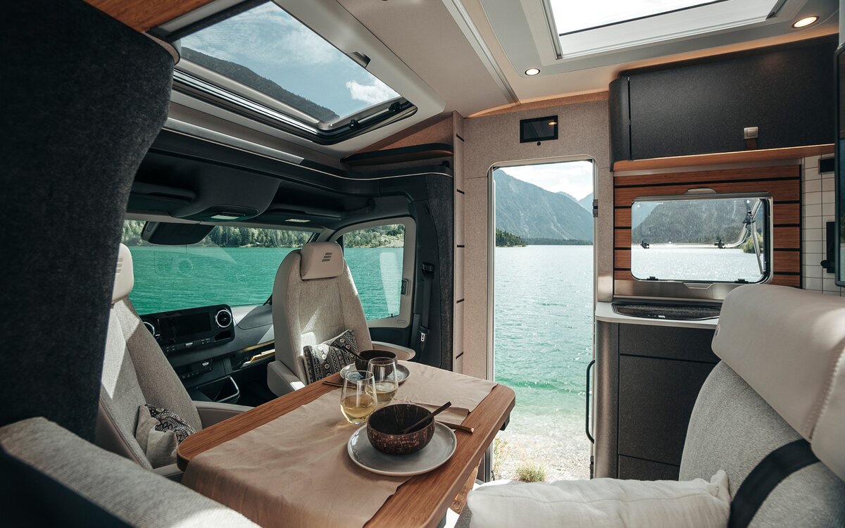 Beim Blick durch den Innenraum des HYMER ML-T in der Stilwelt Native Bamboo ermöglichen zahlreiche Fenster und Türen den Blick auf die Landschaft.