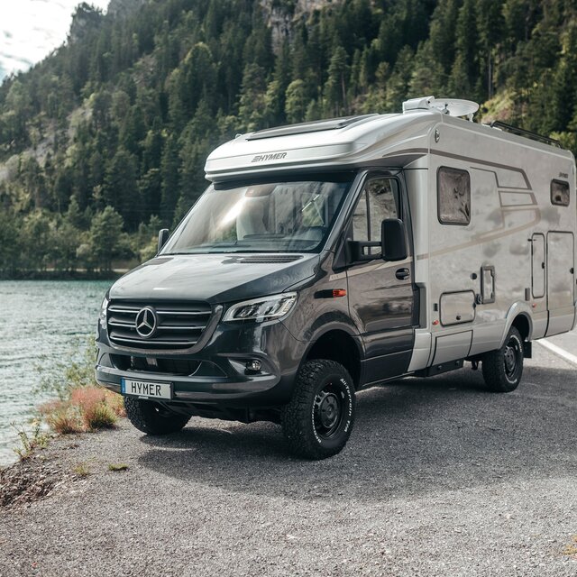 Der HYMER ML-T ist frontal zu sehen, wie er vor einem Gebirgssee steht.