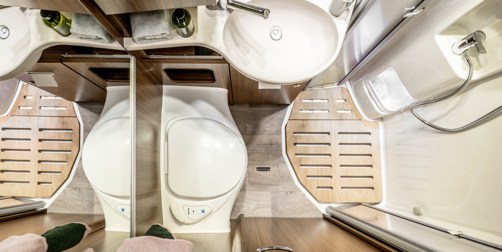 Comfortbadkamer in de HYMER ML-T van bovenaf gezien: douchecabine met houten lattenbodem, wastafel, spiegel, toilet, opbergkasten