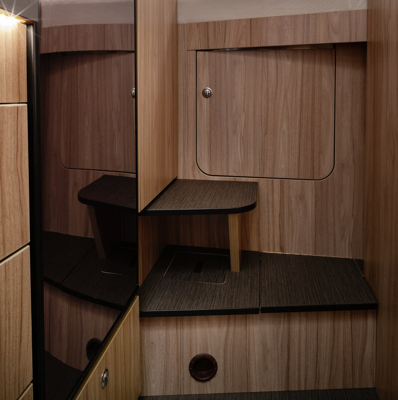 Steps and closed storage compartment as access to the rear transverse bed in the HYMER ML-T