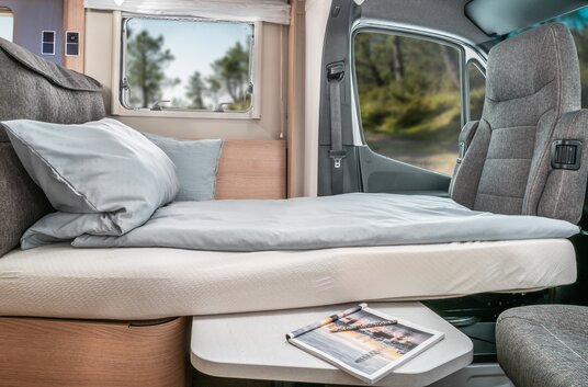 Seating group converted into a bed with a lowered table in the HYMER motorhome