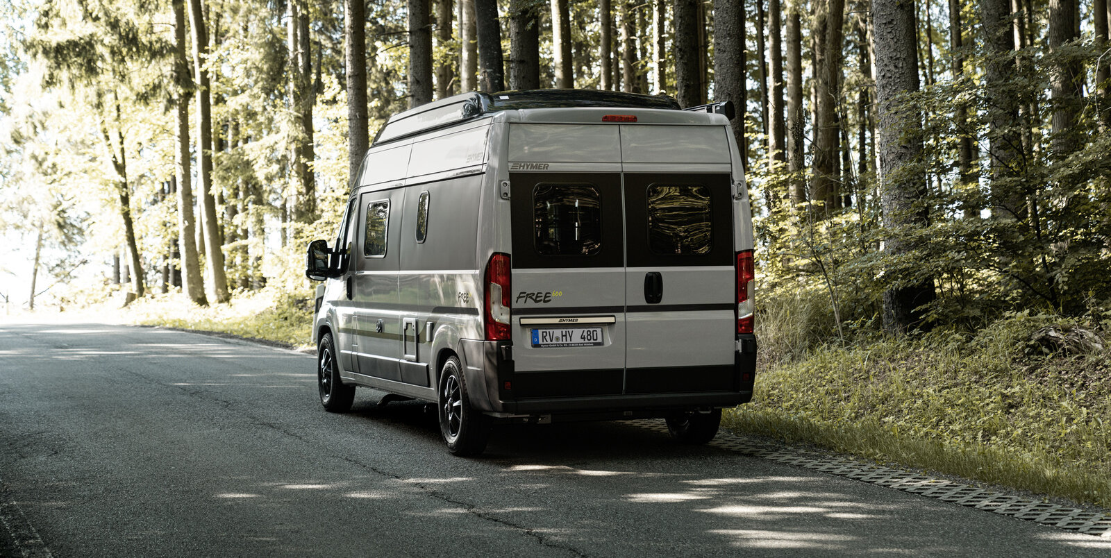 HYMER Free 600 Campus driving on a road through the forest