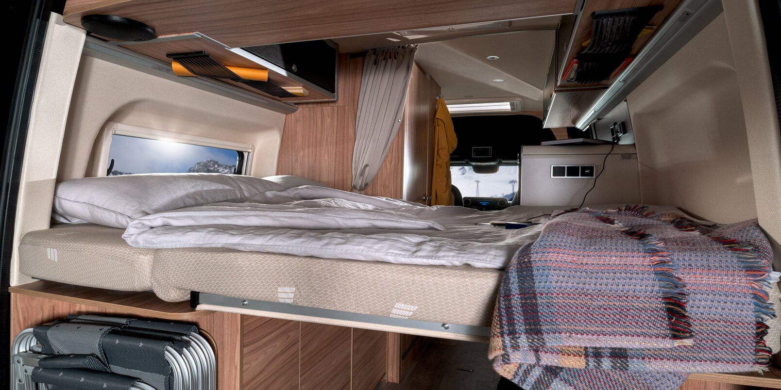 Covered bed area at the rear, blanket, stored camping chairs in the HYMER Grand Canyon S CrossOver